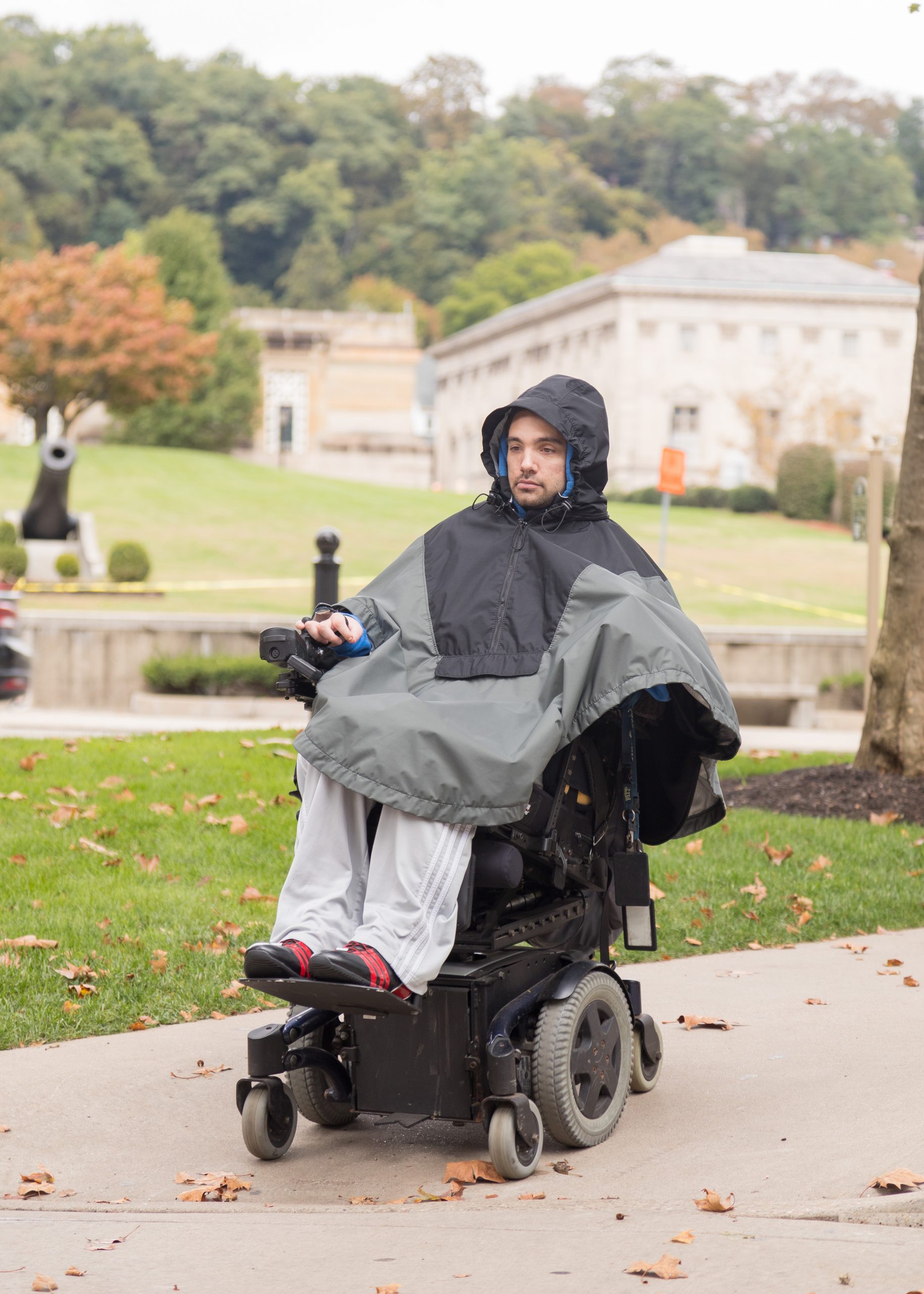 Adult wearing The Winter Cape by Abram's Nation in an electric wheelchair