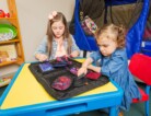 Two young children play with The Fidget Folder by Abram's Nation