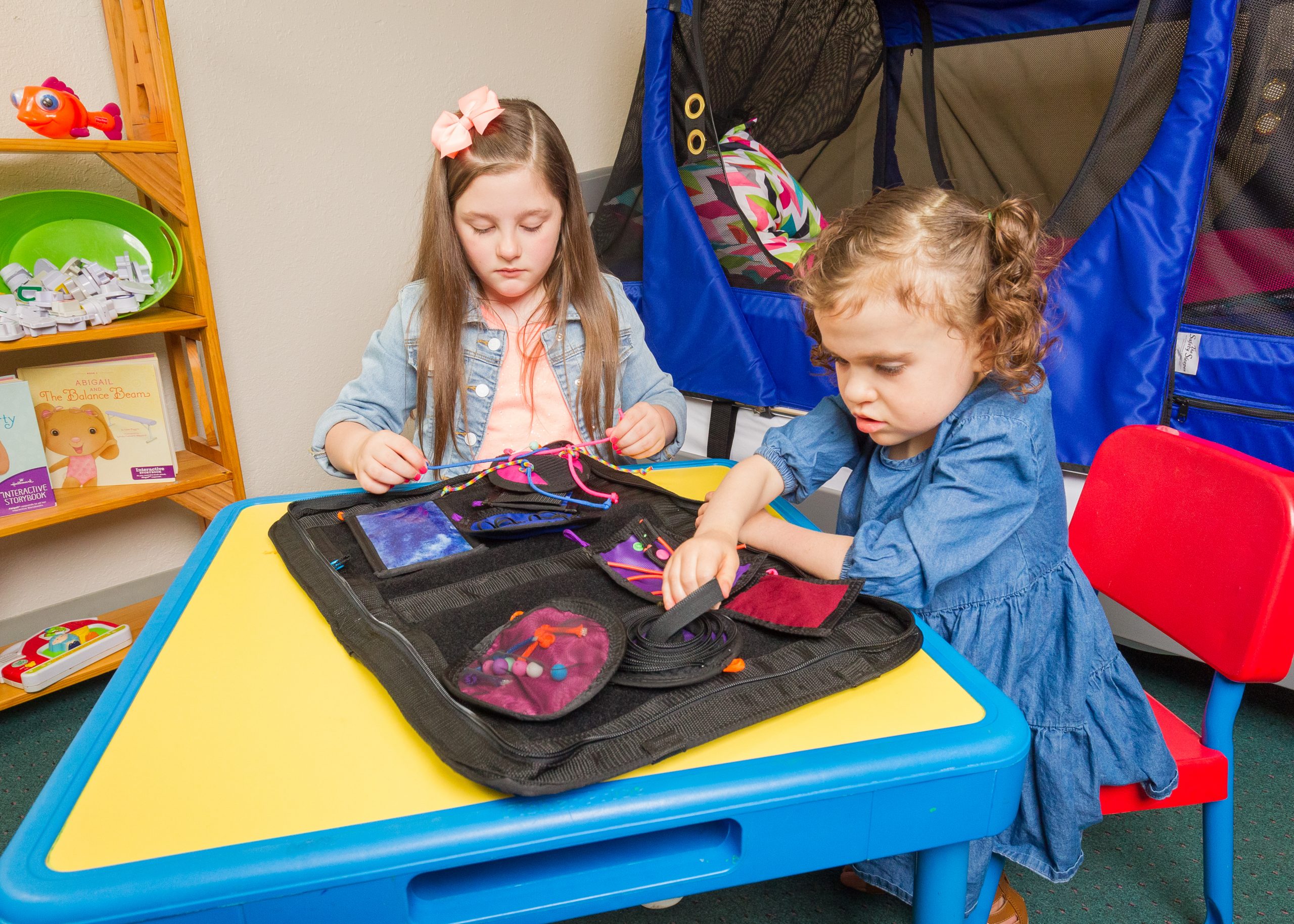 Two young children play with The Fidget Folder by Abram's Nation