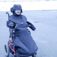 A boy in a wheelchair wearing Koolway Sports warm jacket winter time outside