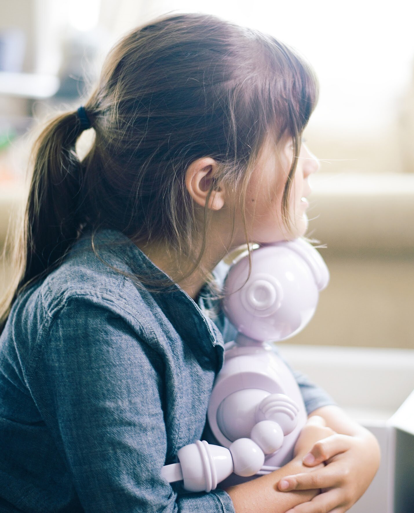 a girl holding Abii the robot on her lap